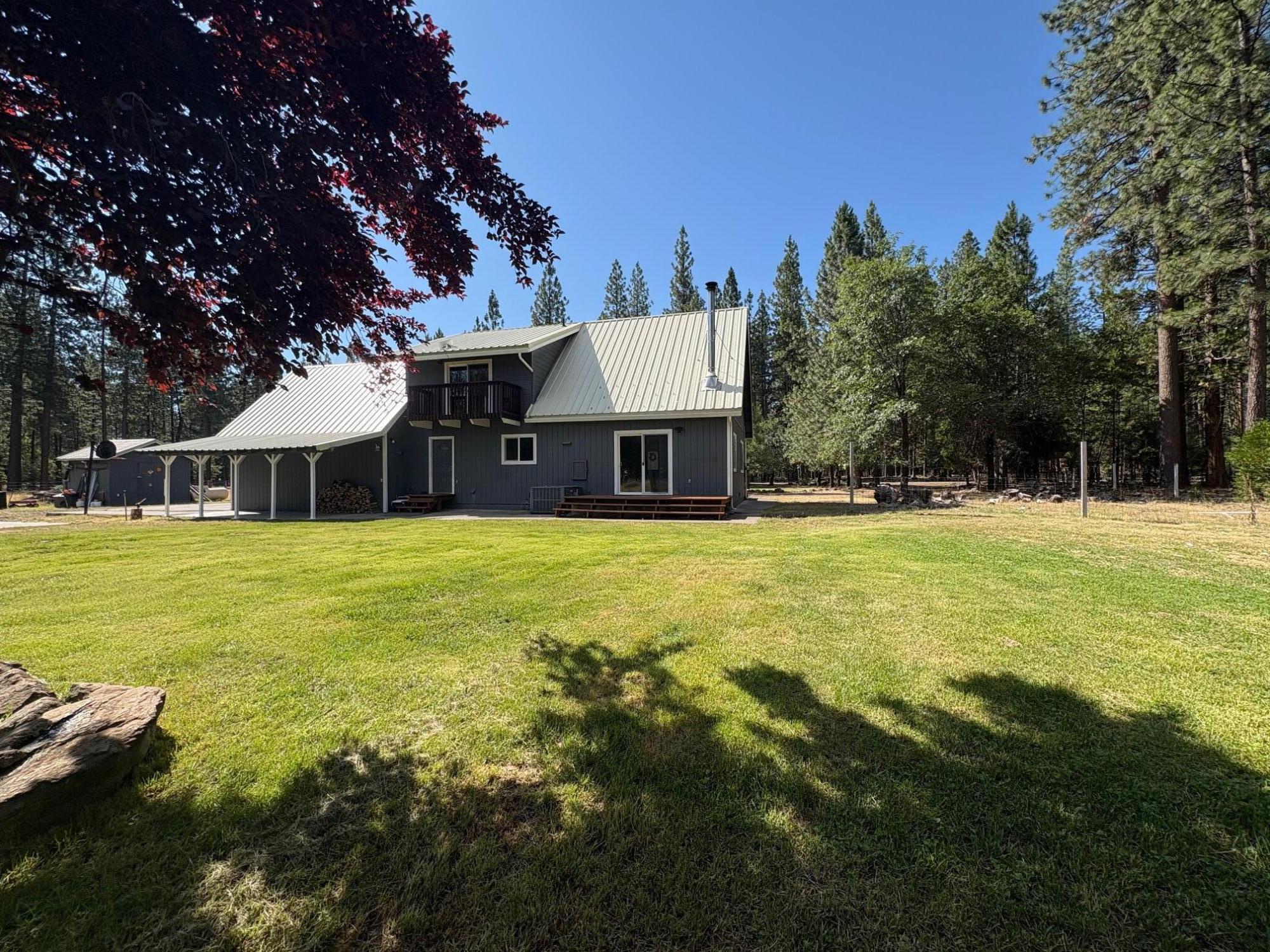 40596 Old School Road Fall River Mills, CA 96028 - Photo 4 of 29 a front view of a house with a yard table and chairs