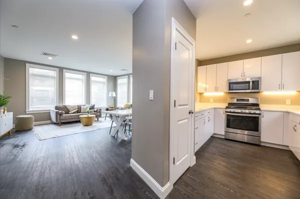 a kitchen with sink a refrigerator and wooden floor