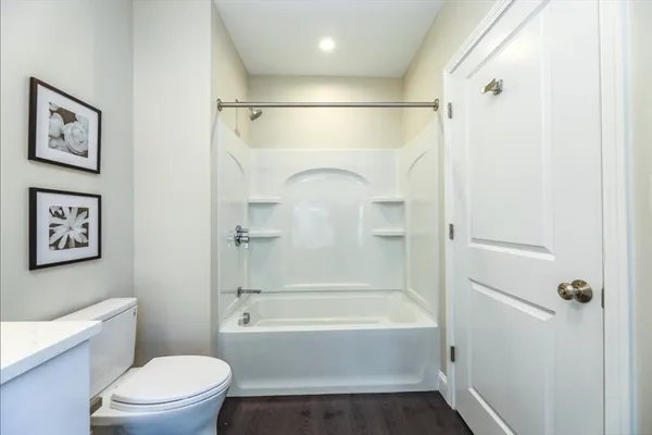 a bathroom with a shower a toilet and a tub