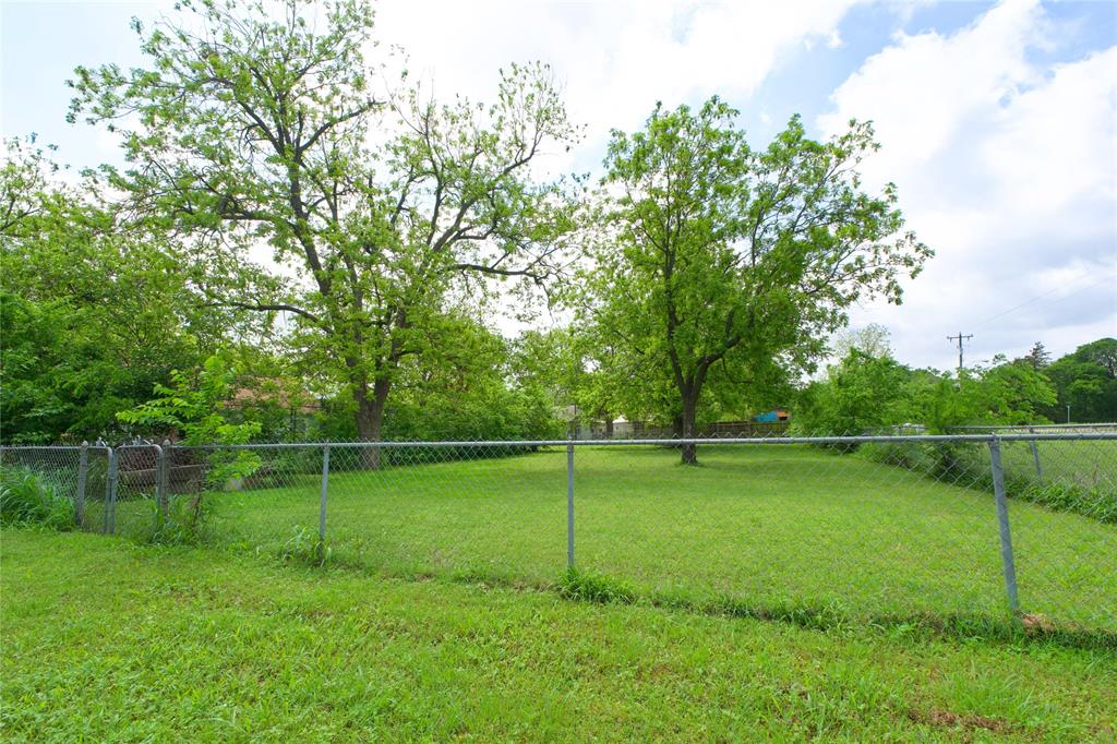 714 Potter Street Gainesville, TX 76240 - Photo 3 of 12 The property features an extensive lawn area with mature trees and a chain-link fence