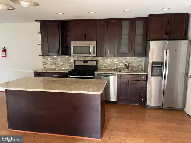 a kitchen with stainless steel appliances granite countertop a stove a refrigerator and a microwave