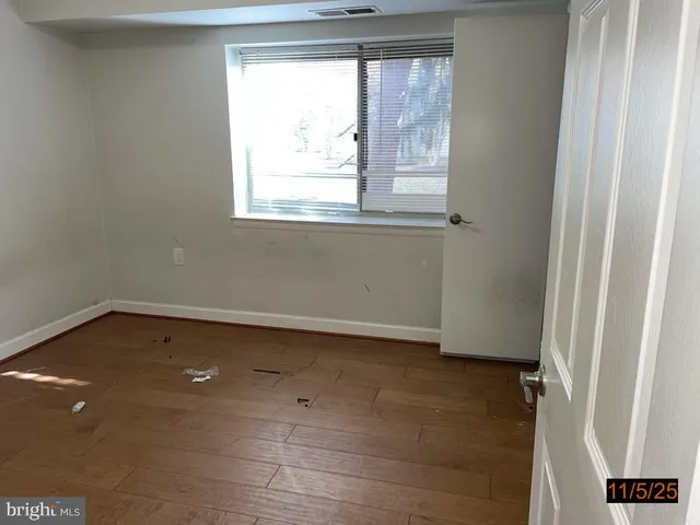 a view of a small space with wooden floor and a window