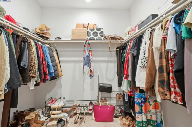 a view of walk in closet with clothes and shoes