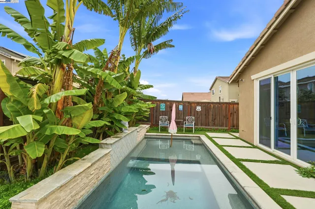 a view of a balcony with a large pool and wooden floor