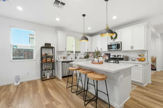 a kitchen with stainless steel appliances kitchen island a refrigerator a stove a sink and a center island