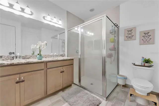 a bathroom with a granite countertop sink a toilet and shower