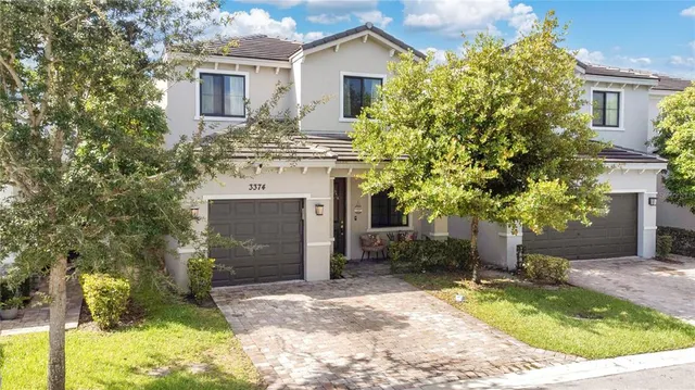 a view of a house with a small yard and potted plants