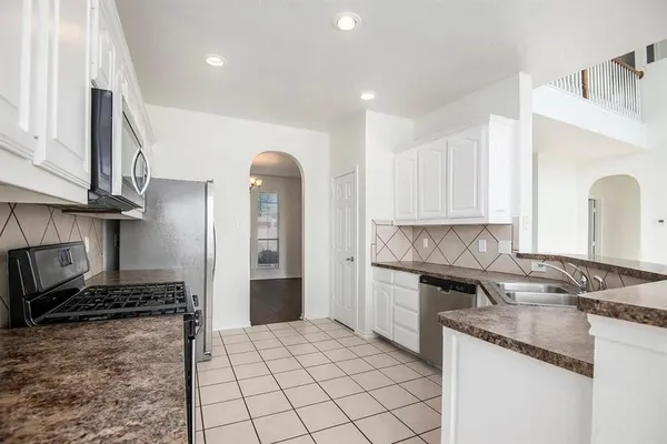 a kitchen with stainless steel appliances granite countertop a stove sink and cabinets