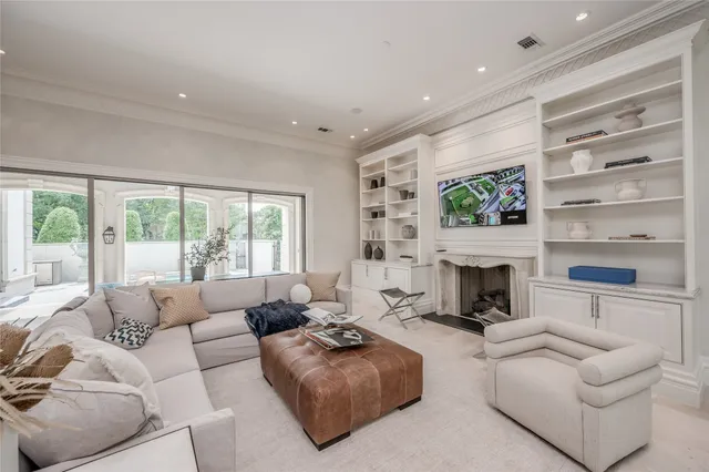 a living room with furniture fireplace and a large window