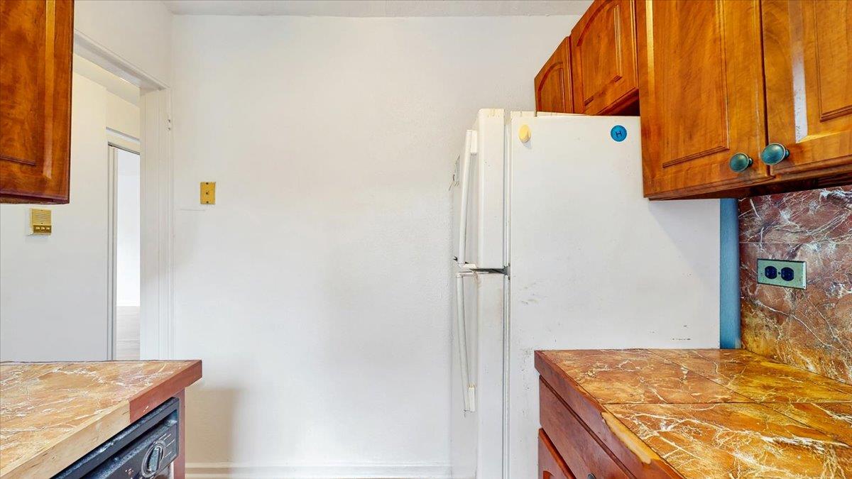 144-15 78th Road, Unit 3A Queens, NY 11367 - Photo 12 of 26 Kitchen with freestanding refrigerator, dishwasher, decorative backsplash, and brown cabinetry
