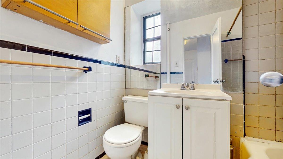 144-15 78th Road, Unit 3A Queens, NY 11367 - Photo 19 of 26 Full bathroom with tile walls, vanity, and tub / shower combination
