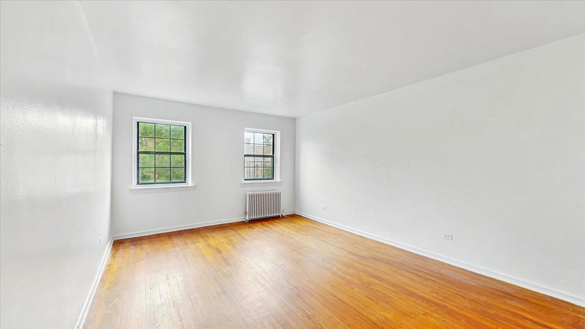 144-15 78th Road, Unit 3A Queens, NY 11367 - Photo 3 of 26 Unfurnished room featuring radiator and light wood-type flooring