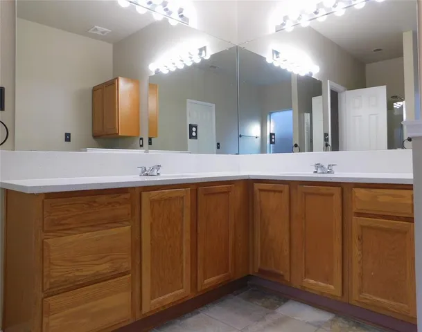 a bathroom with a granite countertop sink and a mirror