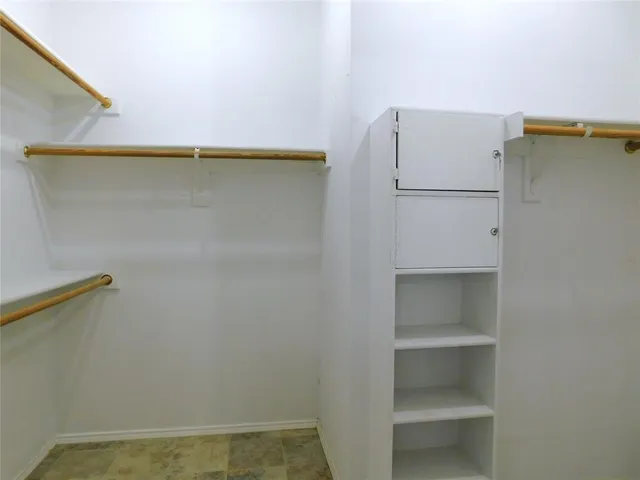 a view of walk in closet with empty racks