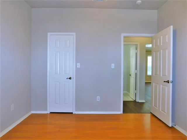 an empty room with wooden floor and closet
