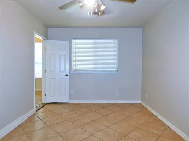 an empty room with chandelier fan