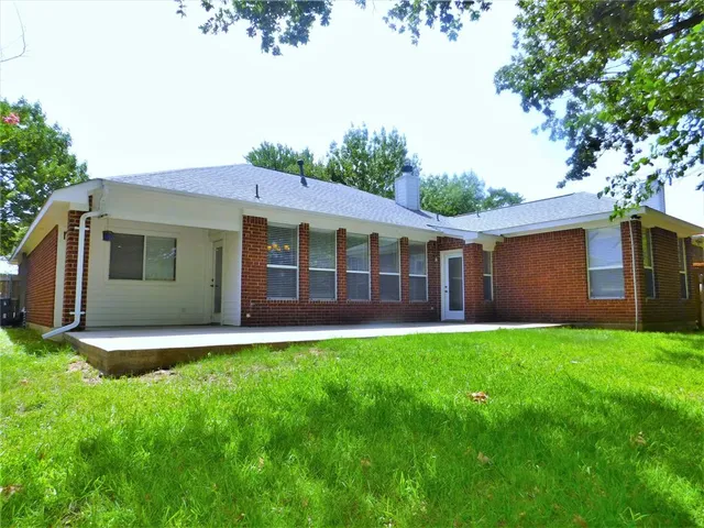 a view of a house with a yard and a large tree