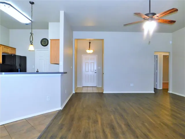 a view of a kitchen with a fridge and wooden floor