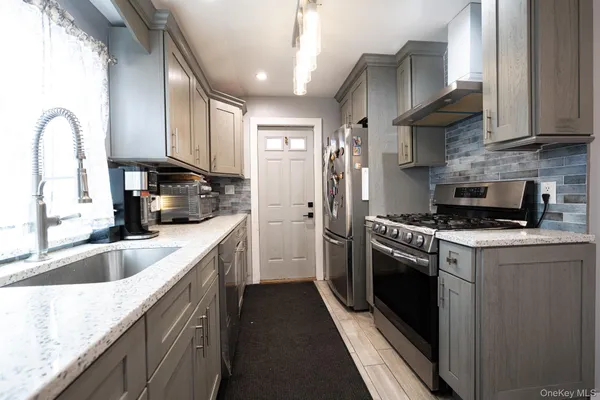 a kitchen with stainless steel appliances a sink a stove and cabinets
