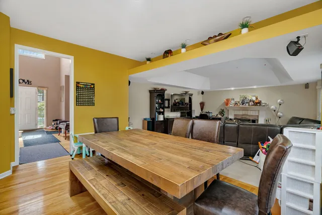 a living room with a table and chairs with wooden floor
