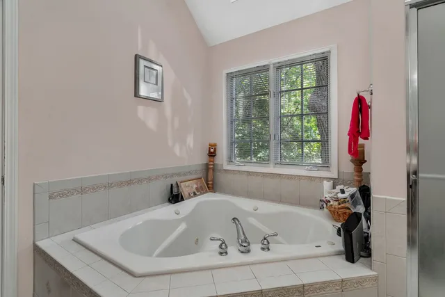 a bathroom with a tub a sink and a window