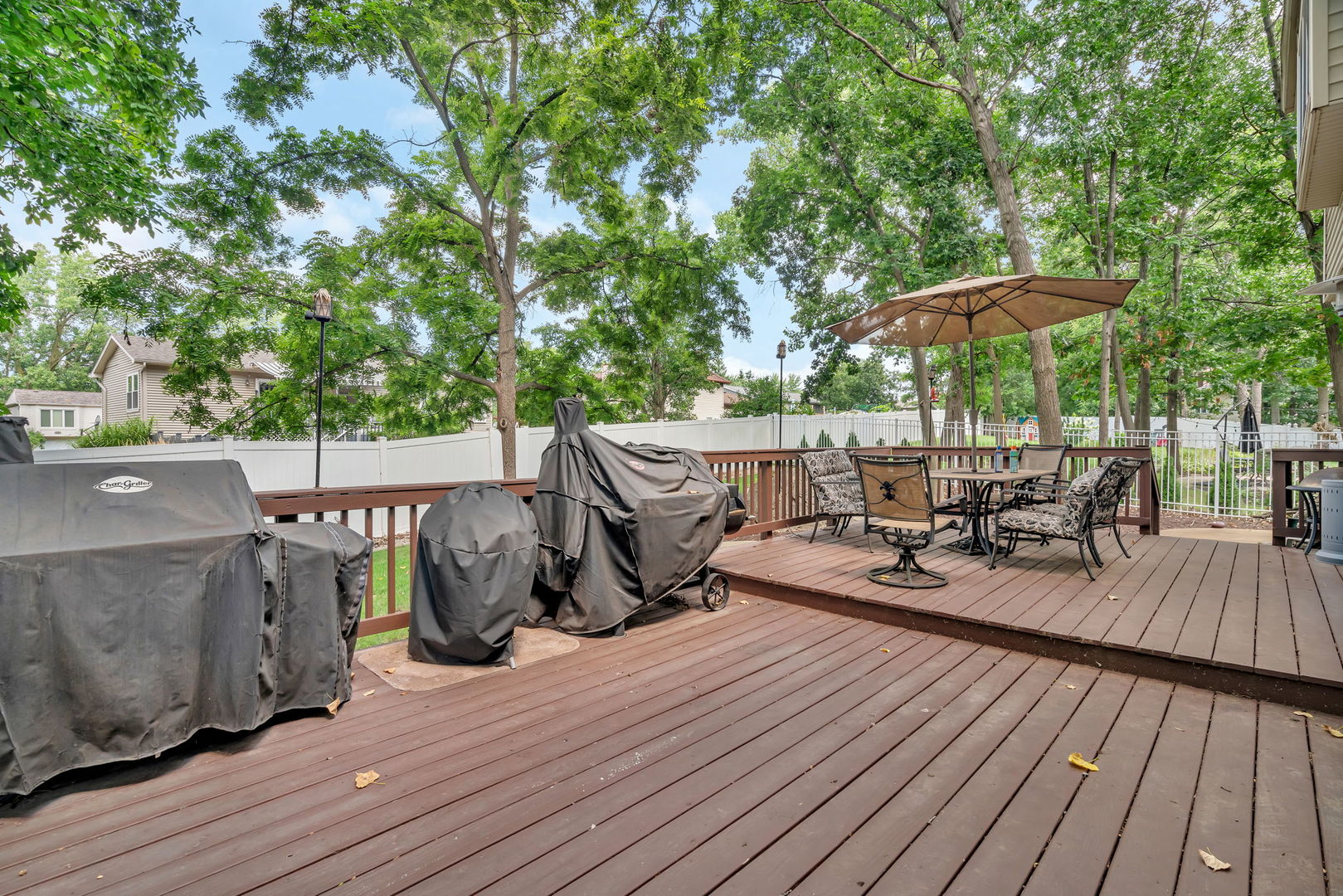745 Feather Sound Drive Bolingbrook, IL 60440 - Photo 37 of 38 a view of a patio with table and chairs under an umbrella with wooden floor