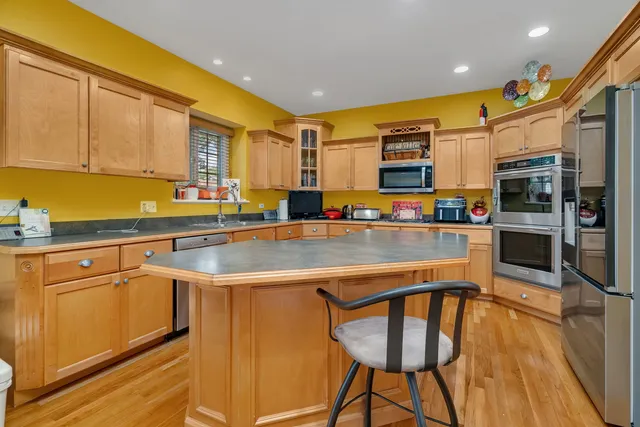 a kitchen with stainless steel appliances granite countertop a sink and a refrigerator