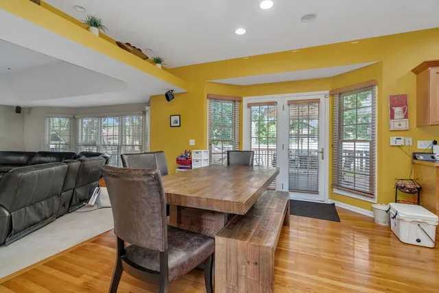 a living room with couches a dining table and chairs with wooden floor
