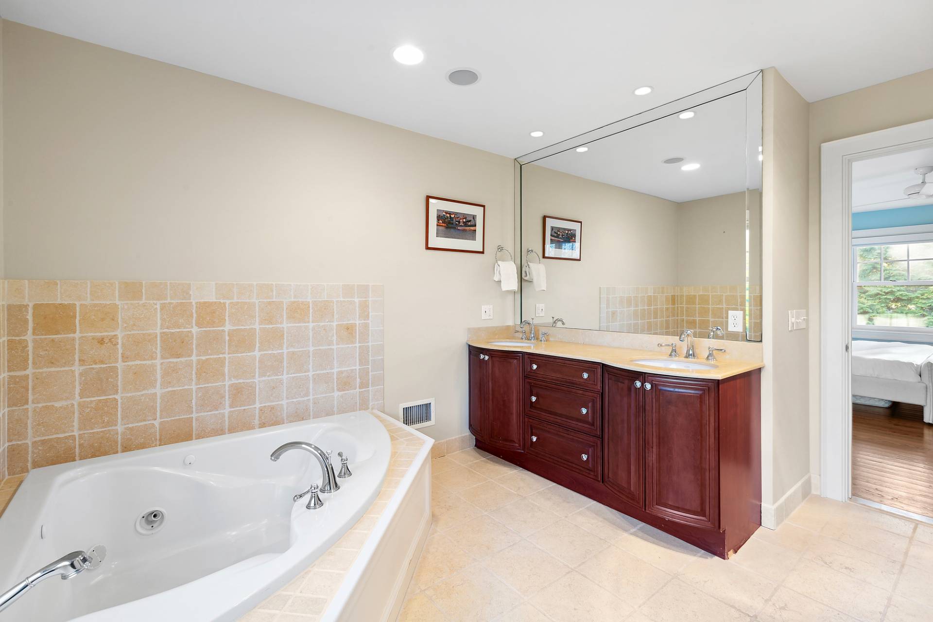 24 Peconic Bay Avenue Southampton, NY 11968 - Photo 9 of 18 a bathroom with a tub sink double vanity granite tub shower and mirror