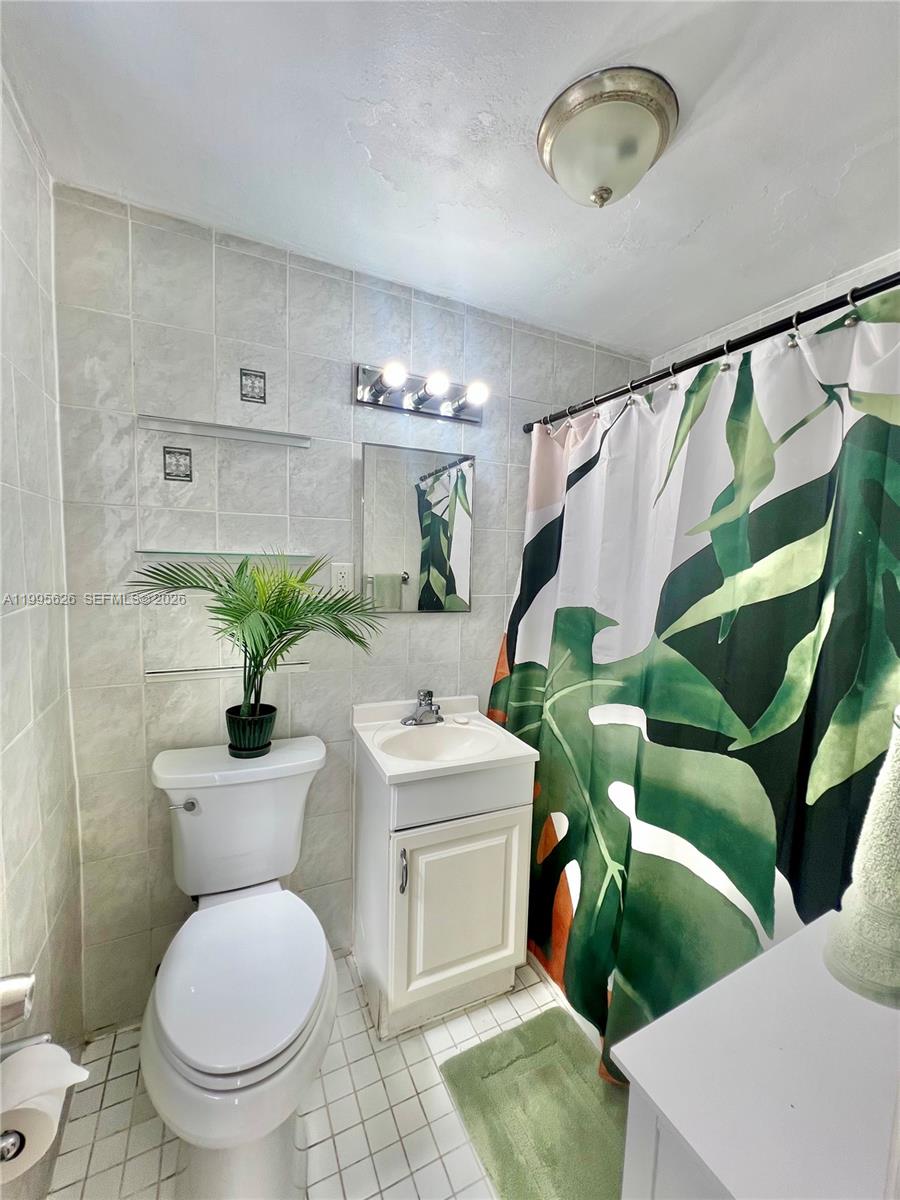 330 74th Street, Unit 5 Miami Beach, FL 33141 - Photo 12 of 19 a bathroom with a toilet sink and mirror