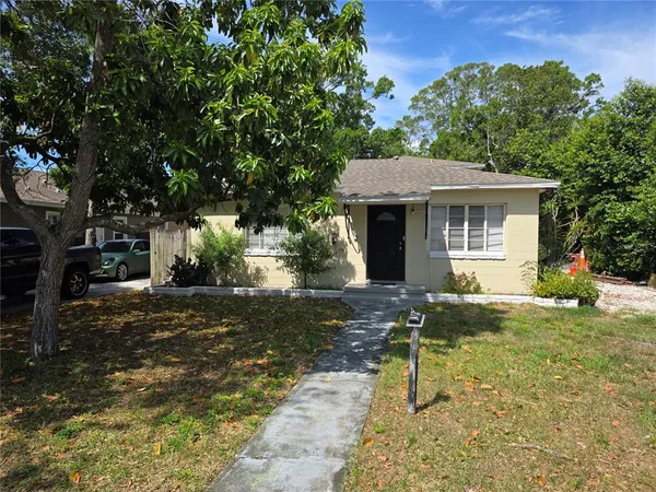 a view of a house with backyard and a tree
