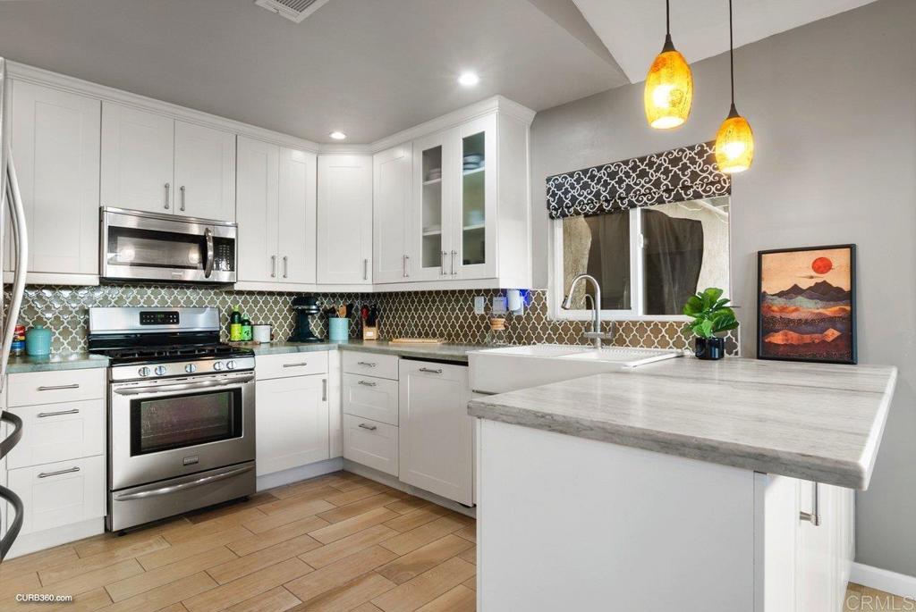 1963 Alderbrook Place Chula Vista, CA 91913 - Photo 6 of 30 a kitchen with a sink cabinets and stainless steel appliances