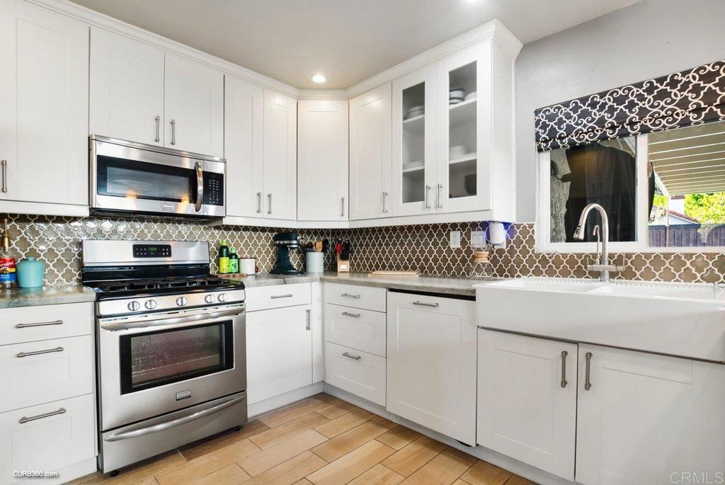 1963 Alderbrook Place Chula Vista, CA 91913 - Photo 8 of 30 a kitchen with granite countertop a sink a stove and cabinets