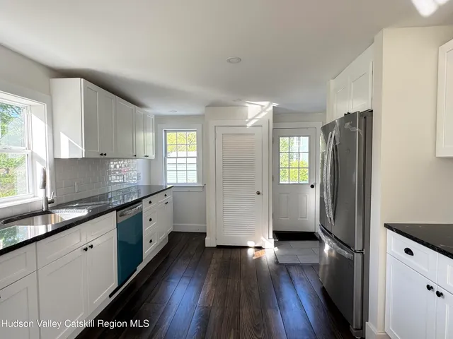 a kitchen with granite countertop a refrigerator stove and sink