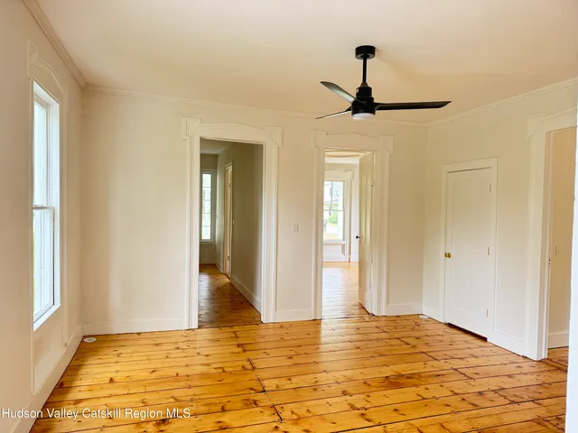 a view of empty room with window and wooden floor