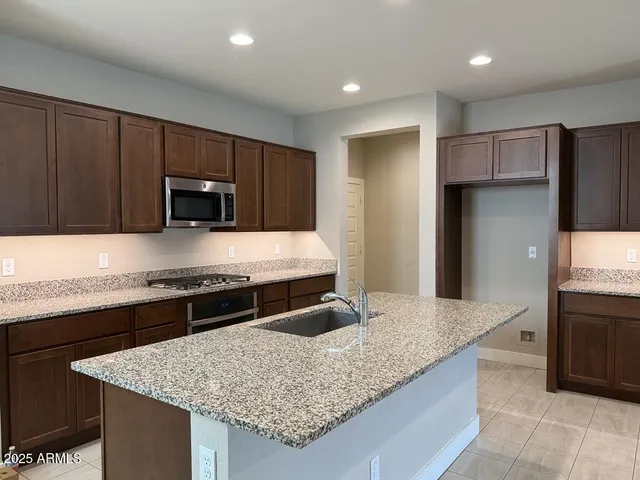 a kitchen with stainless steel appliances granite countertop granite counter tops and wooden cabinets