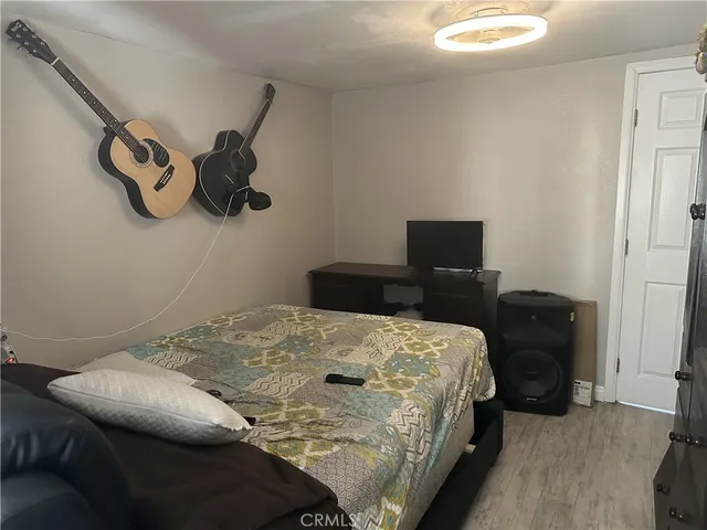 a bedroom with a bed and wooden floor