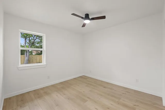 a view of a room with wooden floor and a window