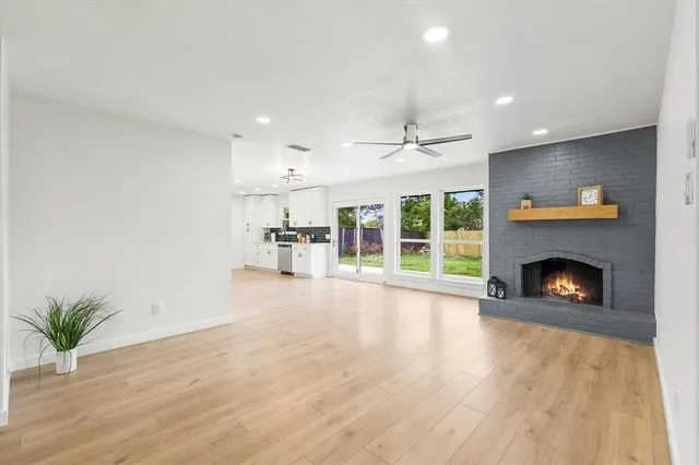 a view of an empty room with a fireplace and a window