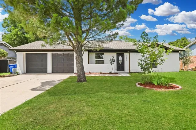 a front view of a house with a garden and yard