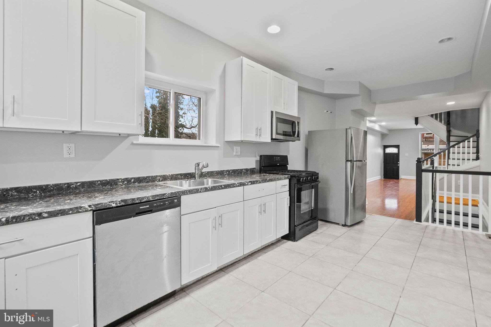 2706 Greenmount Avenue Baltimore, MD 21218 - Photo 3 of 20 a kitchen with granite countertop white cabinets a refrigerator and a sink