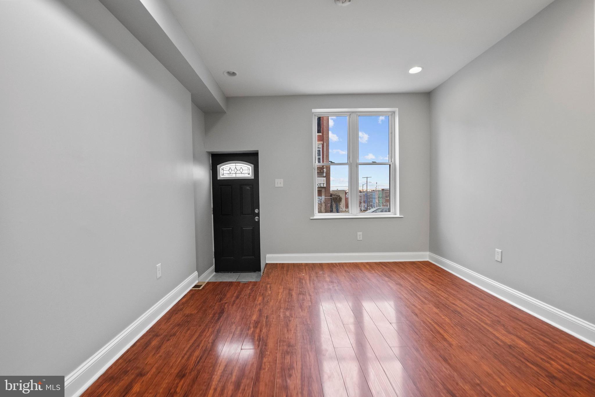 2706 Greenmount Avenue Baltimore, MD 21218 - Photo 4 of 20 an empty room with wooden floor and windows