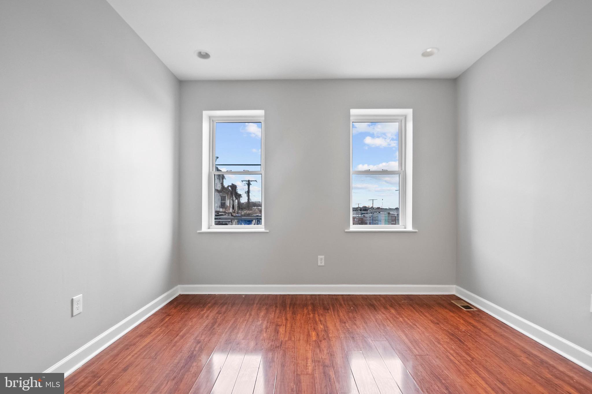 2706 Greenmount Avenue Baltimore, MD 21218 - Photo 8 of 20 a view of an empty room with wooden floor and a window