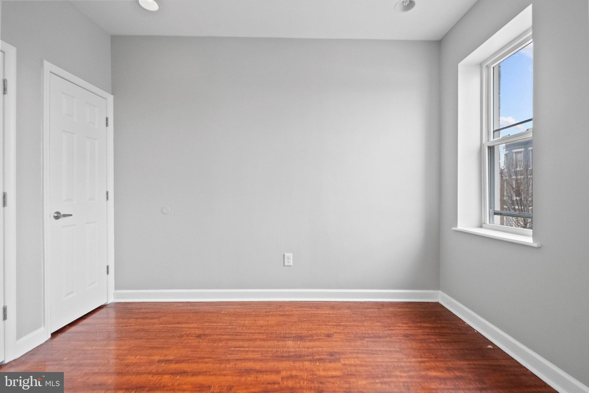 2706 Greenmount Avenue Baltimore, MD 21218 - Photo 10 of 20 a view of an empty room with wooden floor and a window