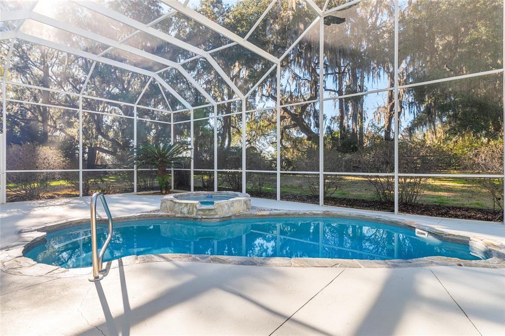 10614 Southwest 15th Lane Gainesville, FL 32607 - Photo 70 of 85 a view of a swimming pool with a tub and wooden fence