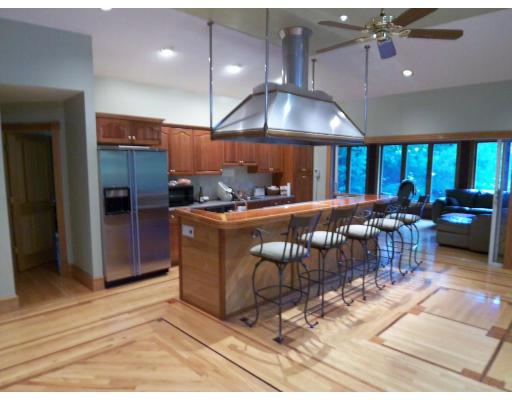 70 Stowell Road Ashburnham, MA 01430 - Photo 4 of 17 a kitchen with stainless steel appliances kitchen island granite countertop a table chairs and a refrigerator