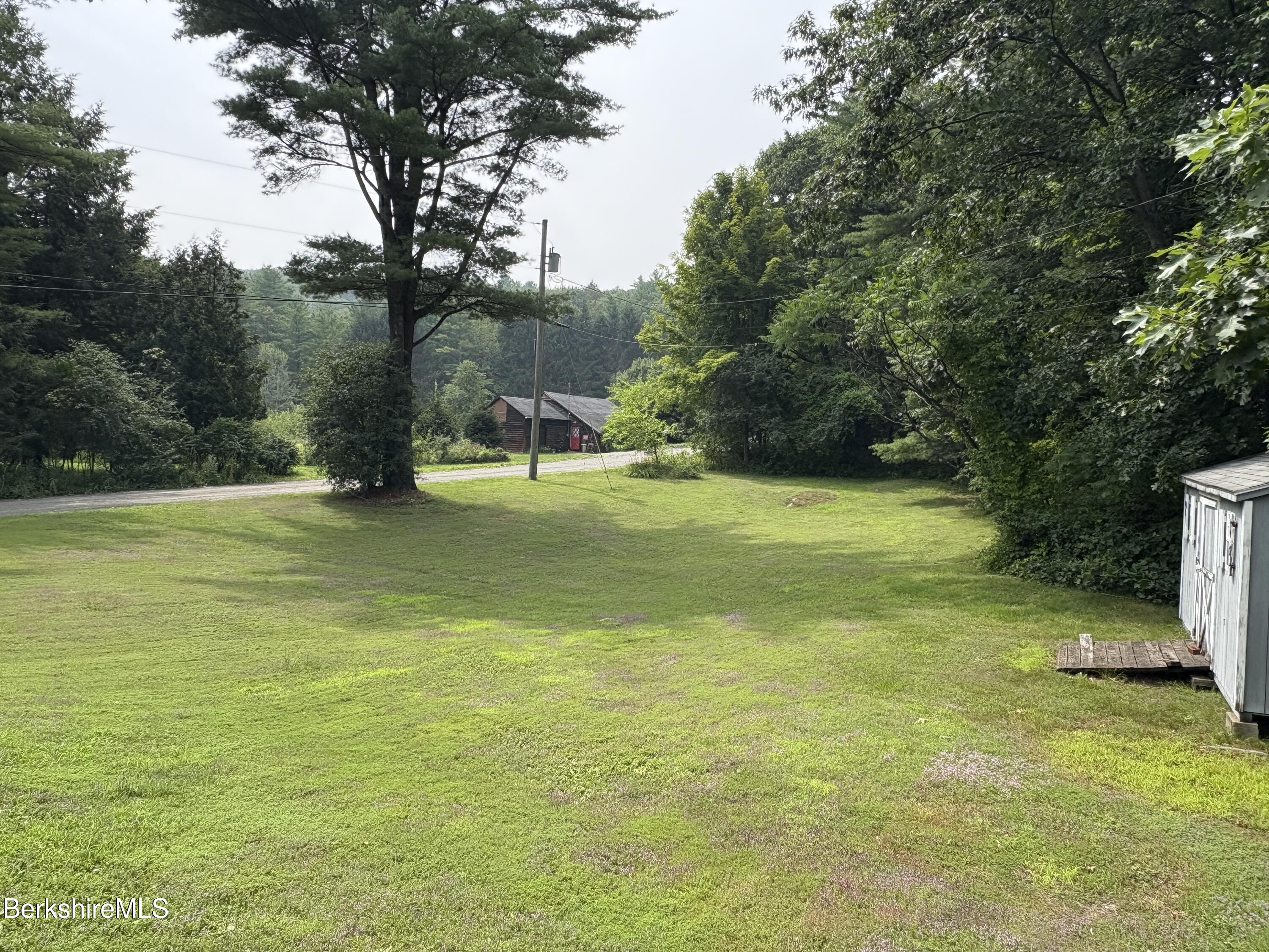 59 High Street West Stockbridge, MA 01236 - Photo 4 of 25 a view of a lake with a bench and trees