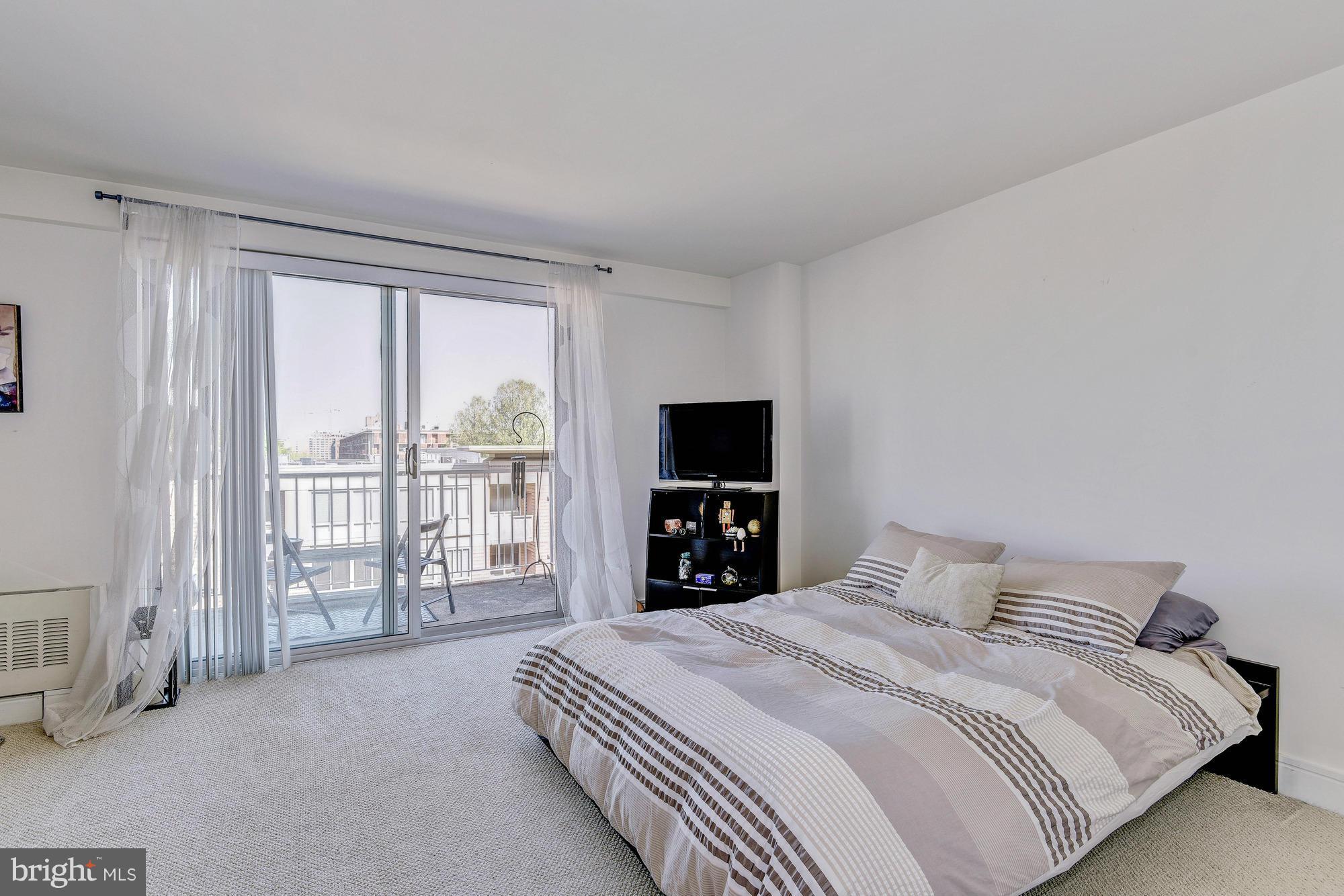 800 4th Street Southwest, Unit S615 Washington, DC 20024 - Photo 13 of 28 a bedroom with a large bed and a tv