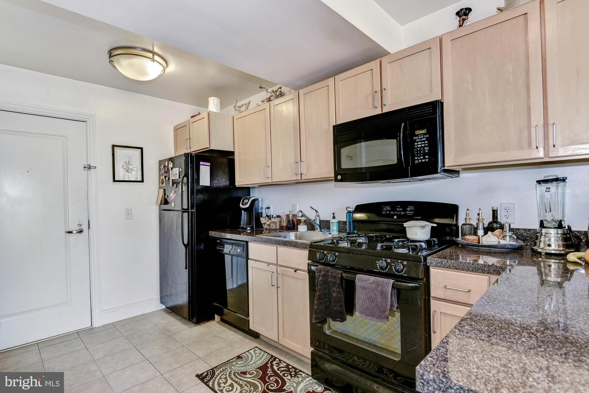 800 4th Street Southwest, Unit S615 Washington, DC 20024 - Photo 5 of 28 a kitchen with stainless steel appliances granite countertop a stove a microwave a sink and cabinets