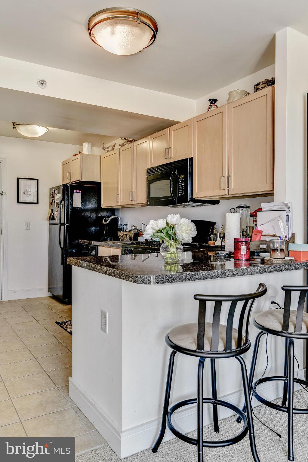 800 4th Street Southwest, Unit S615 Washington, DC 20024 - Photo 7 of 28 a kitchen with stainless steel appliances granite countertop a stove top oven a sink a refrigerator and a microwave